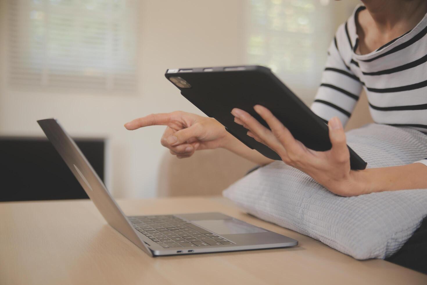 giovane attraente asiatico donna riposo utilizzando navigazione tavoletta computer su divano a casa, contento ragazza seduta su divano rilassare lettura digitale aggeggio con emozionato, comunicazione e stile di vita concetto. foto