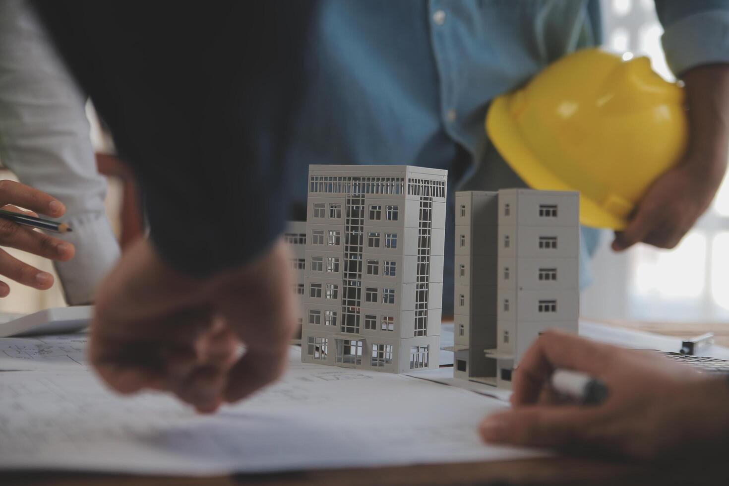 costruzione e struttura concetto di ingegnere o architetto incontro per progetto Lavorando con compagno e ingegneria utensili su modello edificio e planimetria nel Lavorando luogo, contrarre per tutti e due aziende. foto