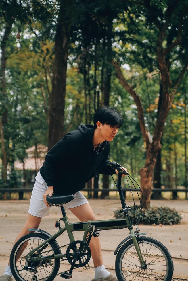 bello contento giovane uomo con bicicletta su un' città strada, attivo stile di vita, persone concetto foto