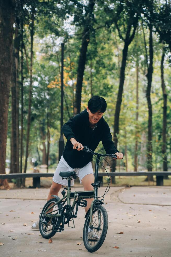 bello contento giovane uomo con bicicletta su un' città strada, attivo stile di vita, persone concetto foto