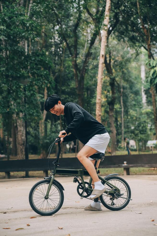 bello contento giovane uomo con bicicletta su un' città strada, attivo stile di vita, persone concetto foto