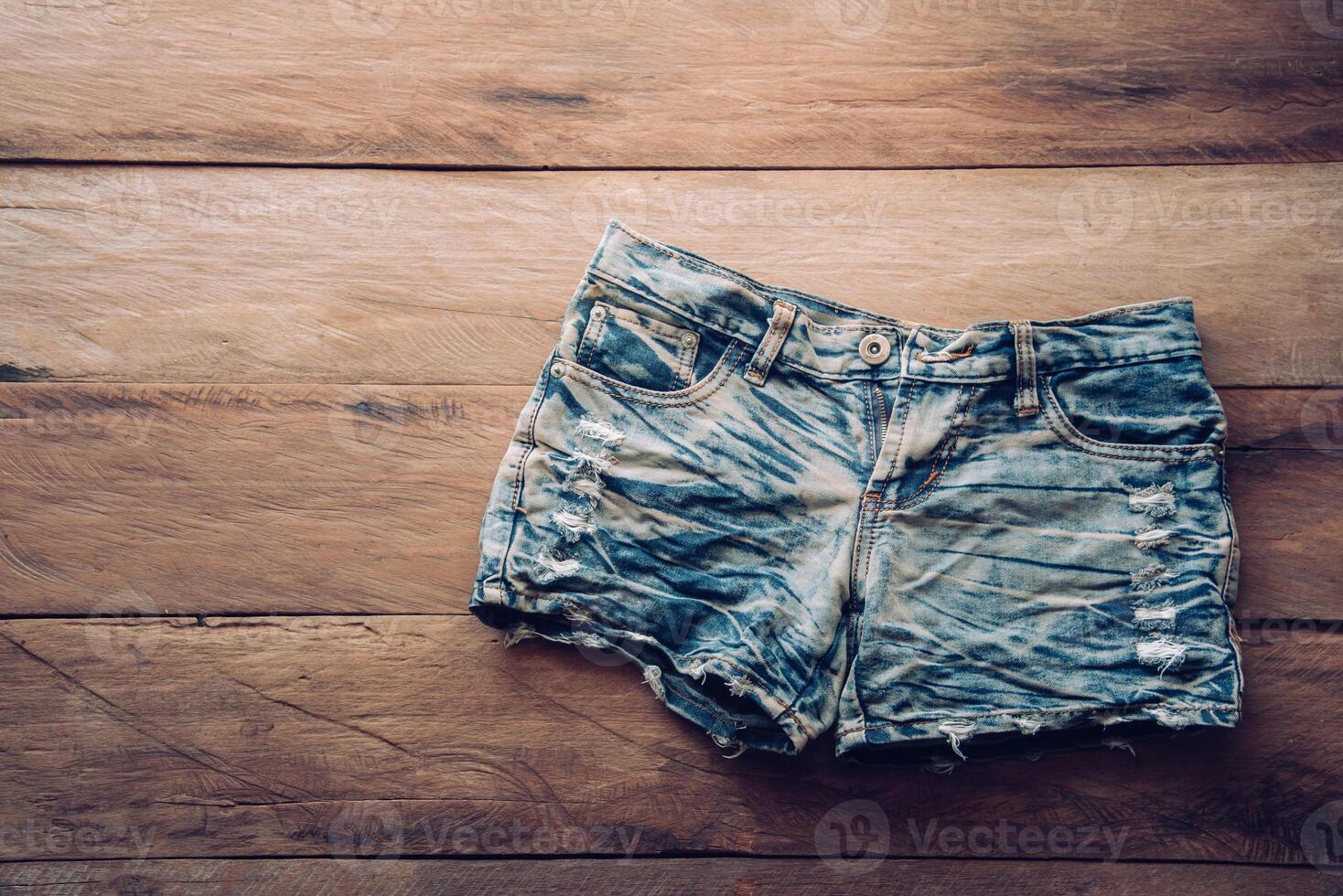 jeans pantaloncini su il di legno pavimento. foto