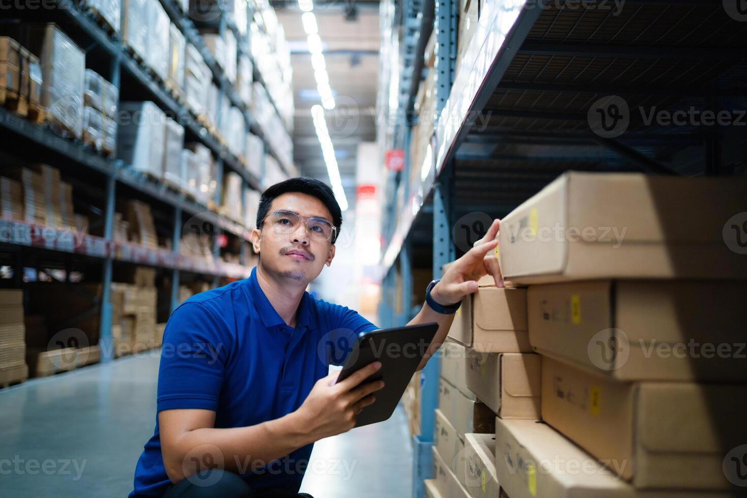 magazzino lavoratori nel blu uniformi uso digitale compresse per dai un'occhiata inventario nel un' grande magazzino. distribuzione centro. la logistica e esportare attività commerciale. foto