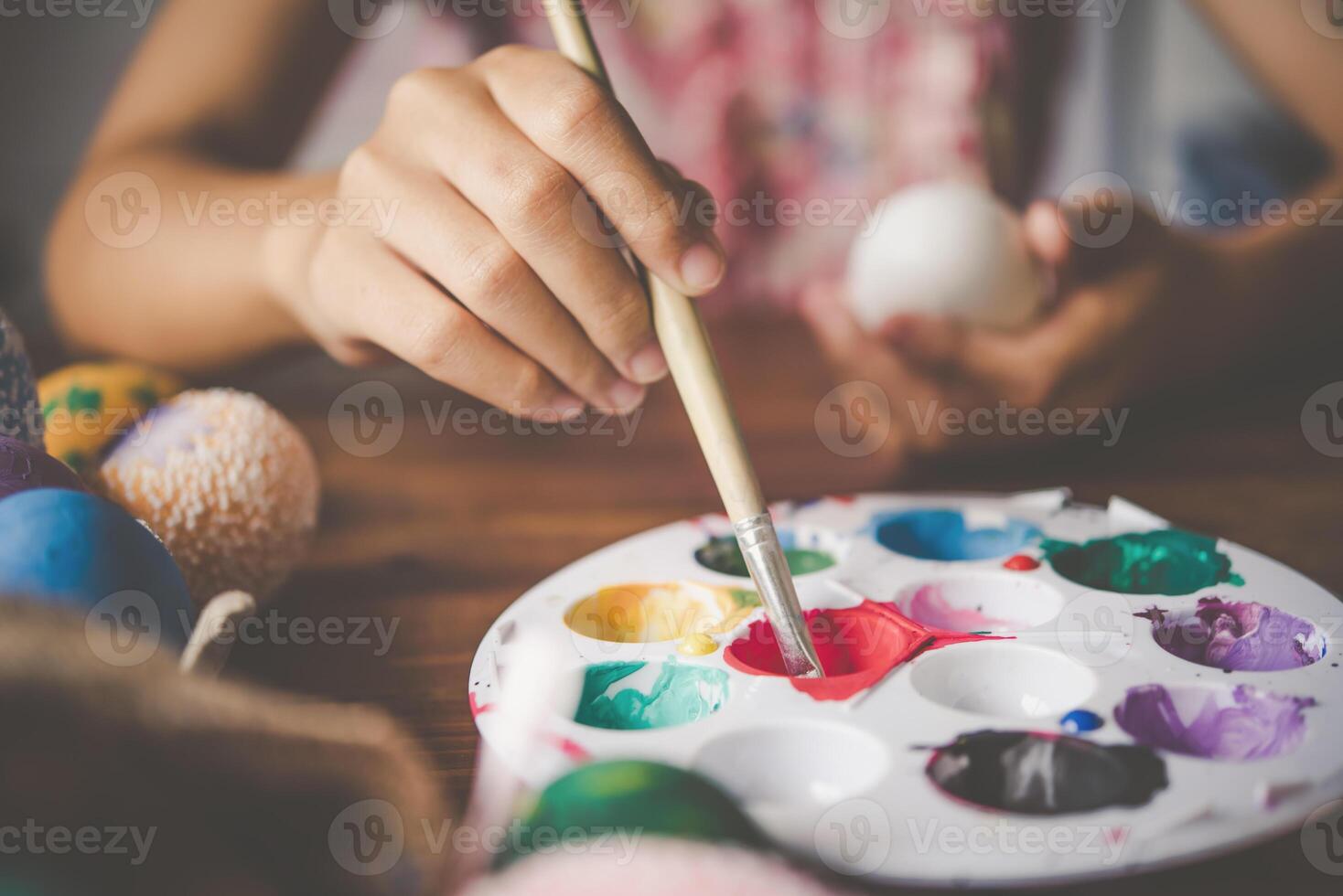 giovane ragazza pittura Pasqua uova per tempo di pasqua a casa foto