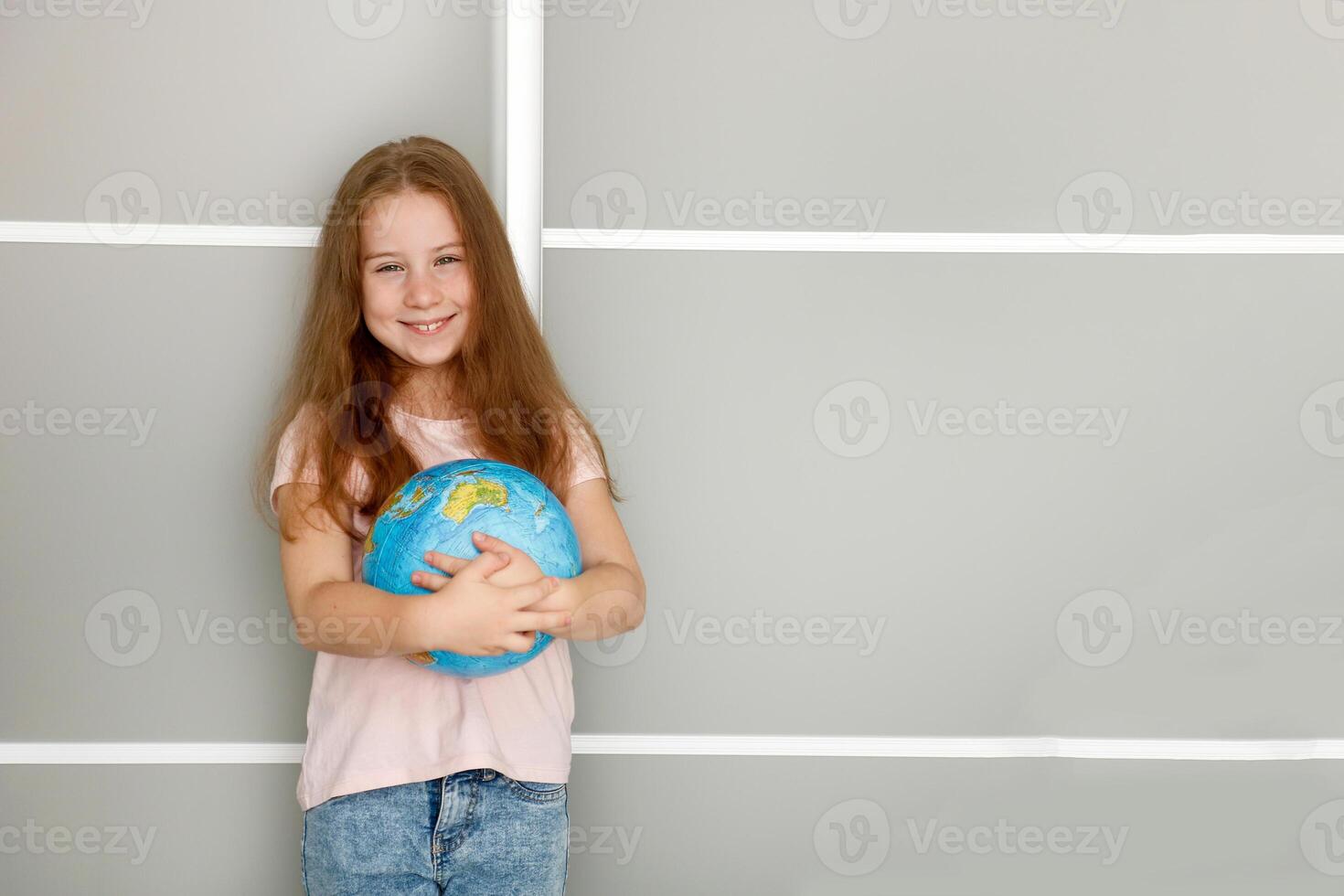 carino gioioso ragazza Tenere un' globo nel sua mani copia spazio foto