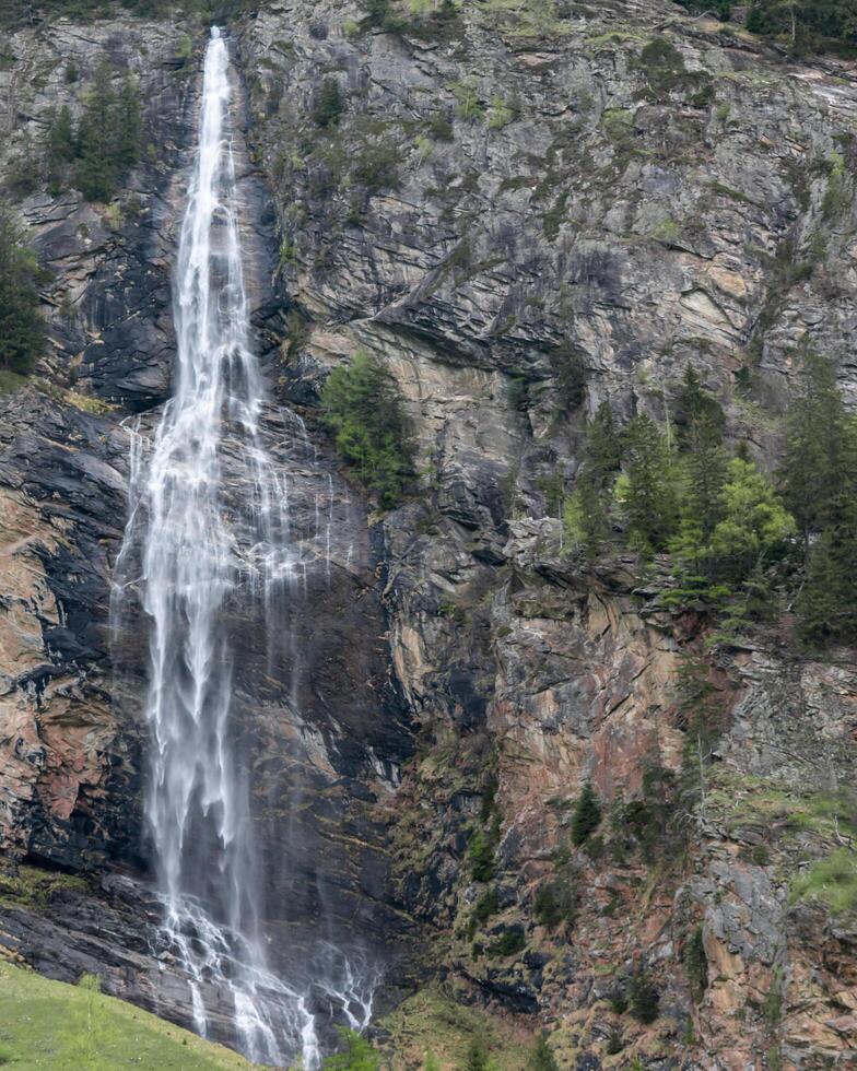 cascata fluente al di sopra di il colorato rocce, Austria. foto