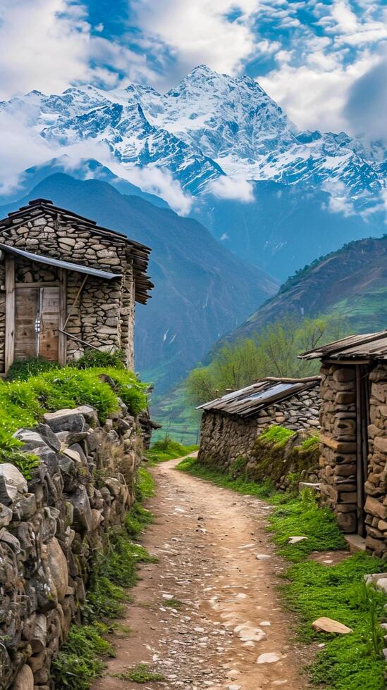 ai generato tranquillo campagna scena stretto sporco sentiero principale passato vecchio pietra e legna strutture, con il maestoso neve capped montagne nel il fondale sotto in parte nuvoloso cielo. ai generato foto