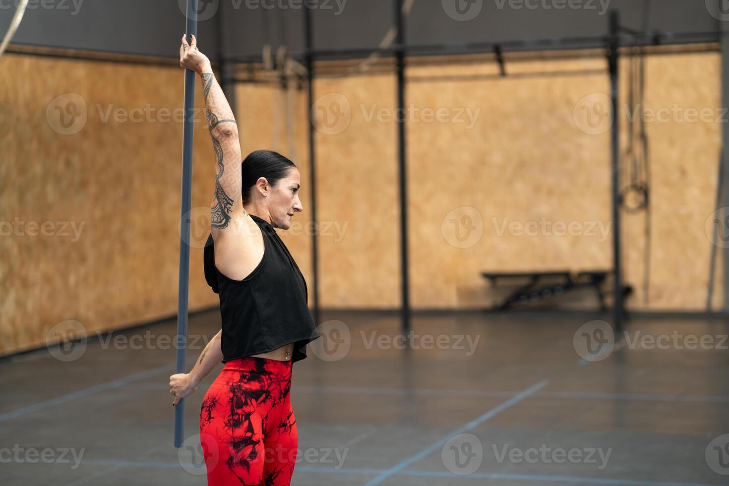 maturo in forma donna allungamento con un' bar nel un' Palestra foto