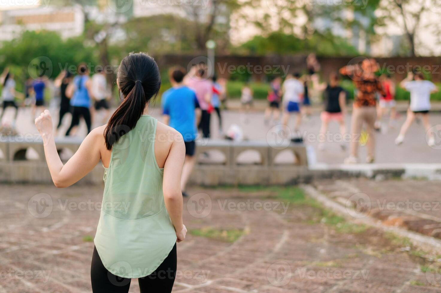 femmina pareggiatore. in forma giovane asiatico donna con verde abbigliamento sportivo aerobica danza esercizio nel parco e godendo un' salutare all'aperto. fitness corridore ragazza nel pubblico parco. benessere essere concetto foto