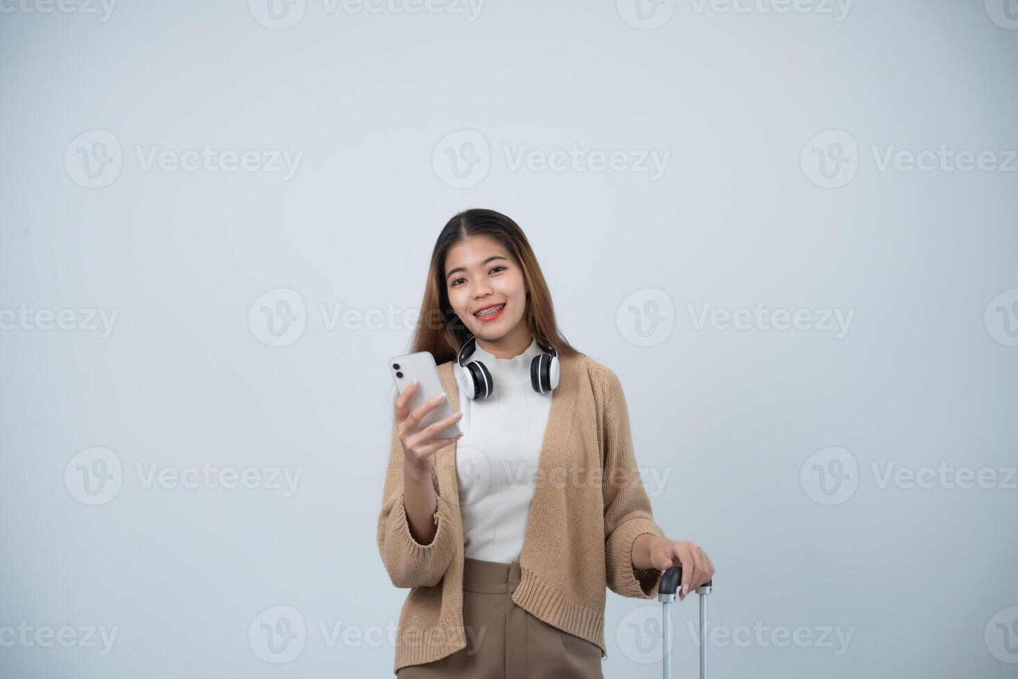 giovane asiatico turista donna con bretelle sorridente indossare cappello e Tenere bagaglio, passaporto, mobile Telefono, spalla Borsa per preparare andando per viaggio su vacanze isolato su bianca o grigio studio sfondo. foto