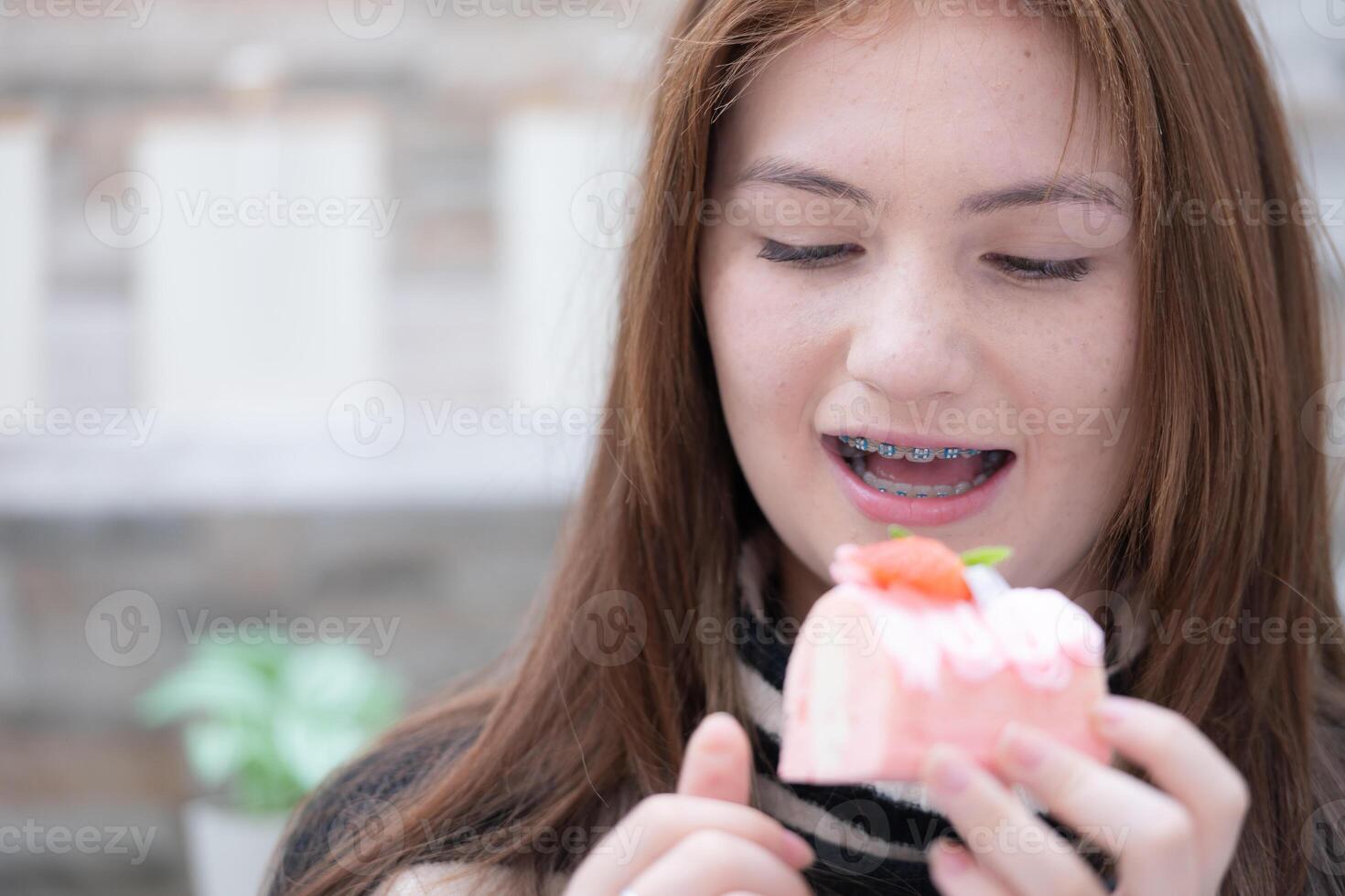 ritratto di adolescenziale ragazze mangiare un' pezzo di torta foto