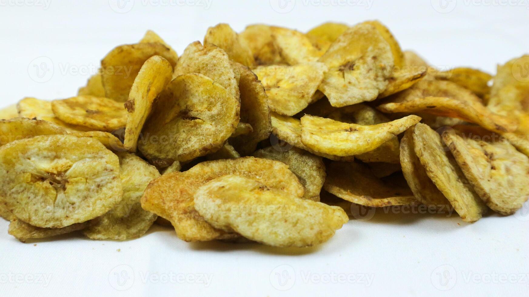 un' ciotola di dolce Banana fritte patatine fritte o keripik pisang manis su un' piazza modello tovagliolo e bianca sfondo. popolare indonesiano tradizionale merenda. selettivo messa a fuoco. foto