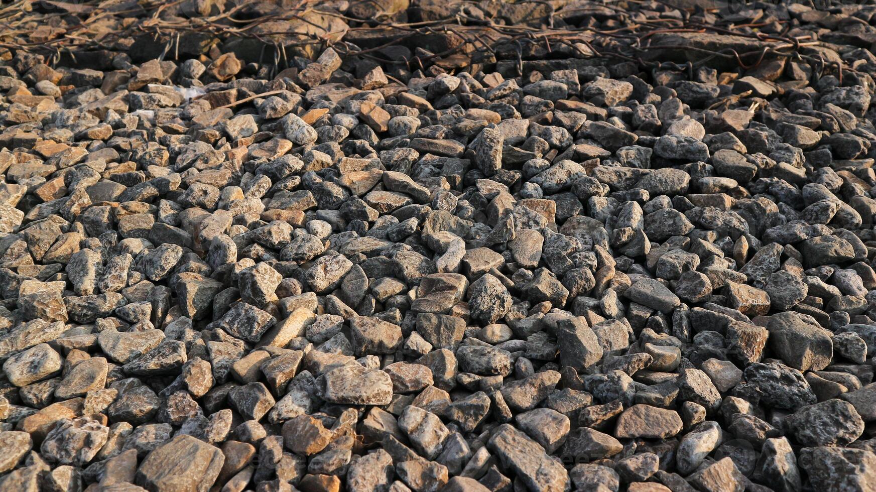 piccolo strada pietra sfondo, buio ghiaia struttura, pietra ciottoli, senza soluzione di continuità struttura. Ferrovia ghiaia. foto