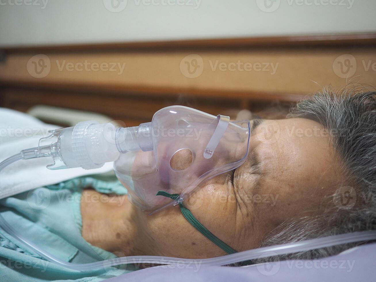 anziano donna ha asma e bisogno nebulizzazione, inalazione terapia di il maschera di inalatore. più vecchio donna ha un' nasale congestione foto