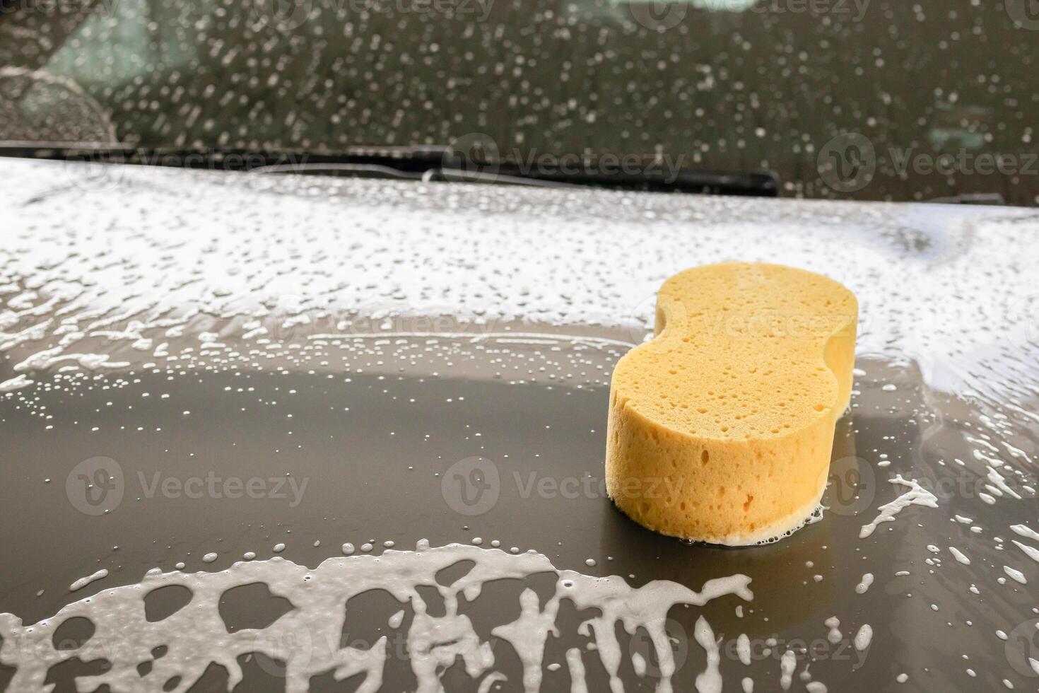 auto pulizia e lavaggio con giallo spugna e schiuma sapone foto