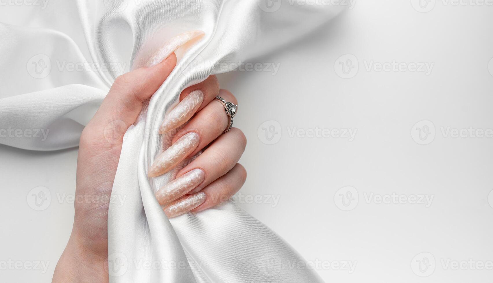 mano di un' giovane donna con bianca perla manicure foto