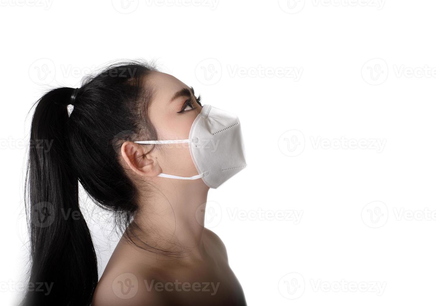 vista laterale della giovane donna asiatica che indossa una maschera respiratore n95 per proteggere dalle malattie respiratorie trasmesse dall'aria come l'influenza covid-19 coronavirus ebola pm2.5 polvere e smog, concetto di infezione da virus di sicurezza foto