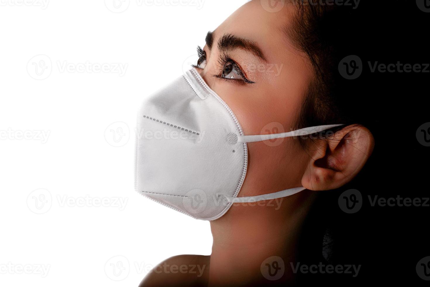 vista laterale della giovane donna asiatica che indossa una maschera respiratore n95 per proteggere dalle malattie respiratorie trasmesse dall'aria come l'influenza covid-19 coronavirus ebola pm2.5 polvere e smog, concetto di infezione da virus di sicurezza foto