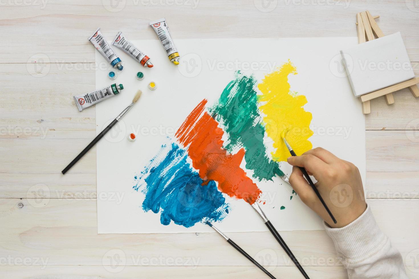 vista dall'alto mano umana pittura carta bianca pennellata colorata foto