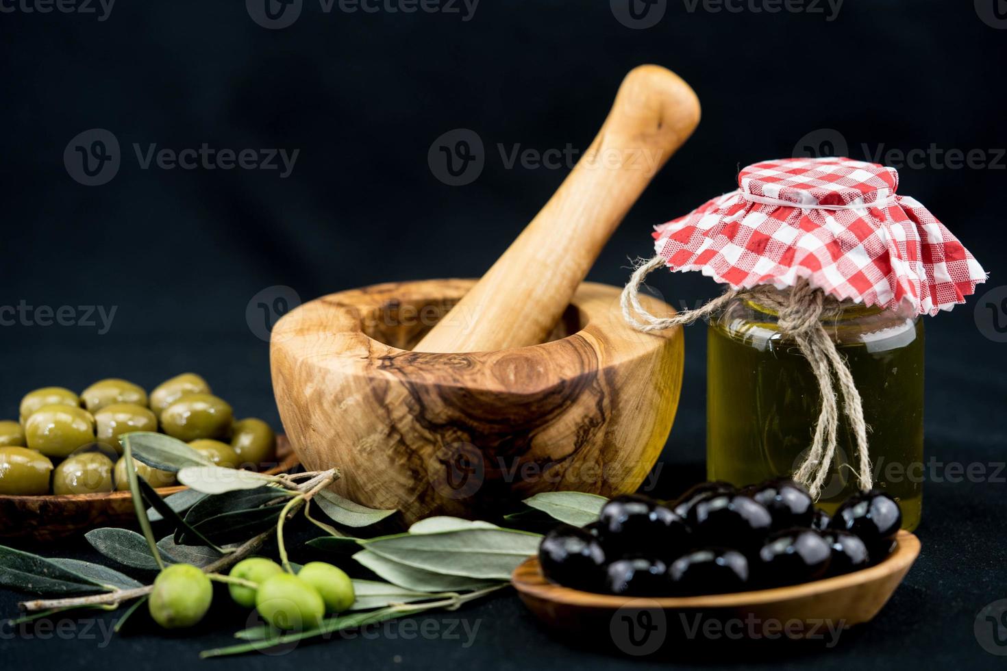 olio d'oliva spremuto a freddo con ramo e frutti foto