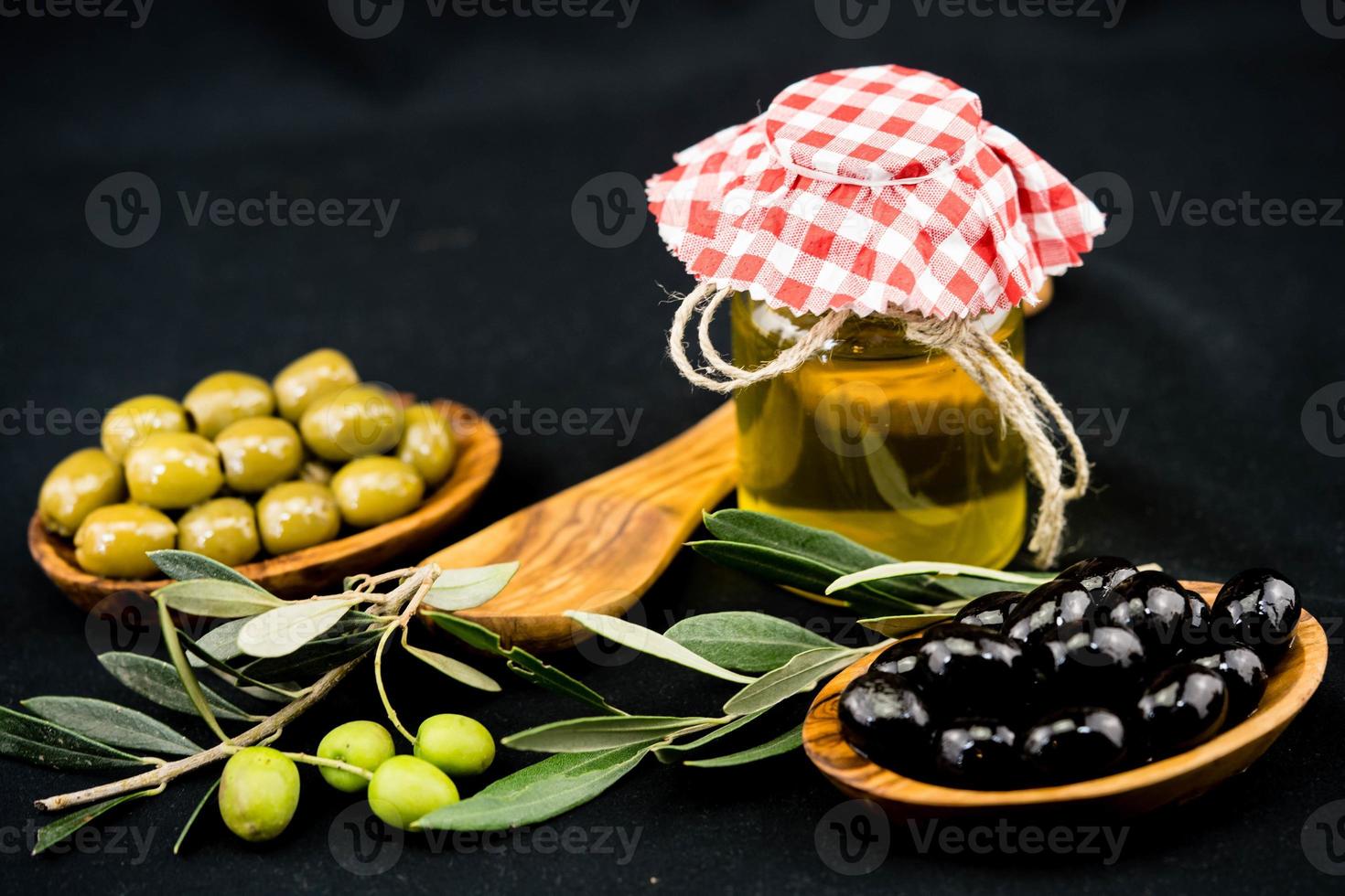 olio d'oliva spremuto a freddo con ramo e frutti foto