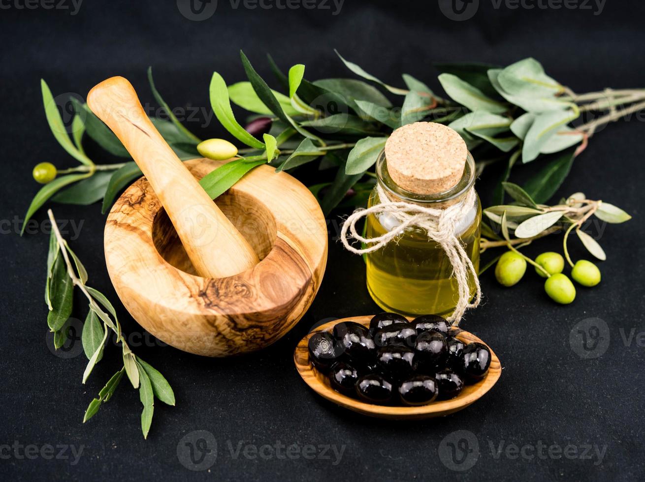 olio d'oliva spremuto a freddo con ramo e frutti foto