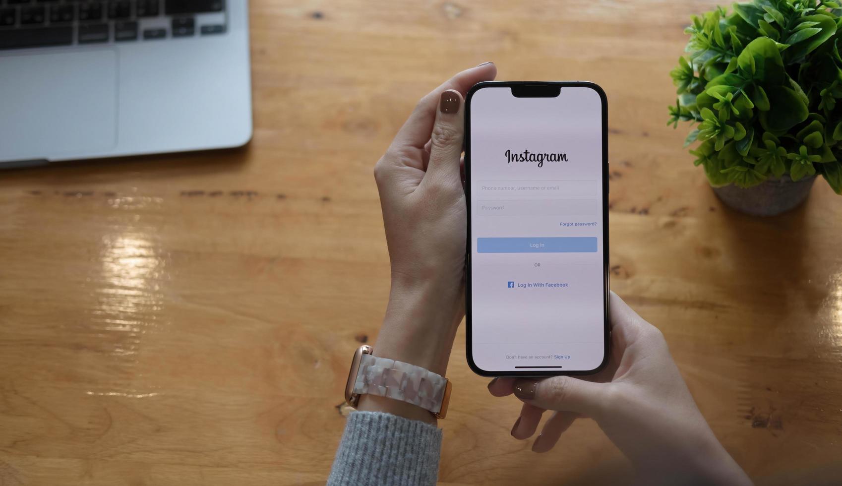 una donna tiene in mano apple iphone 13 pro max con l'applicazione instagram sullo schermo al bar. instagram è un'app di condivisione di foto per smartphone.