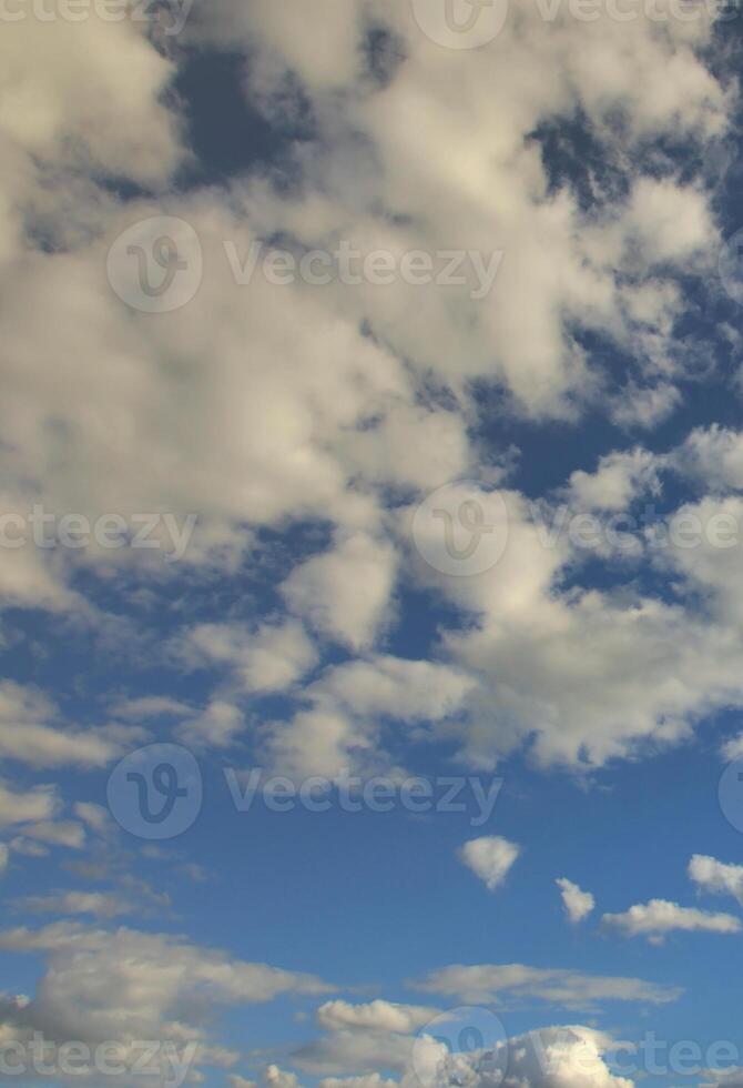 un' blu nuvoloso cielo con molti piccolo nuvole blocco il sole foto