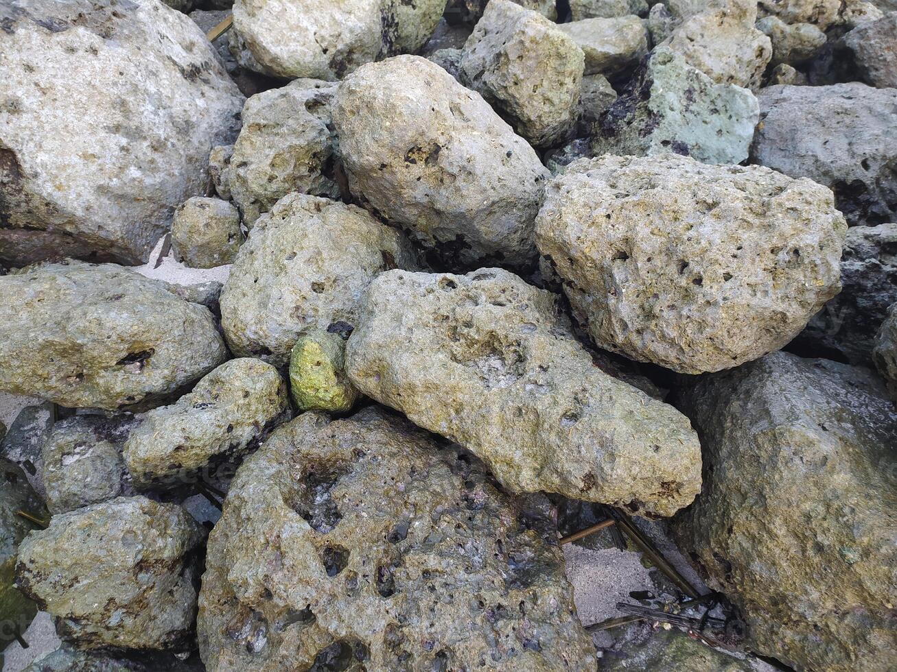 un' mucchio di rocce su il spiaggia foto