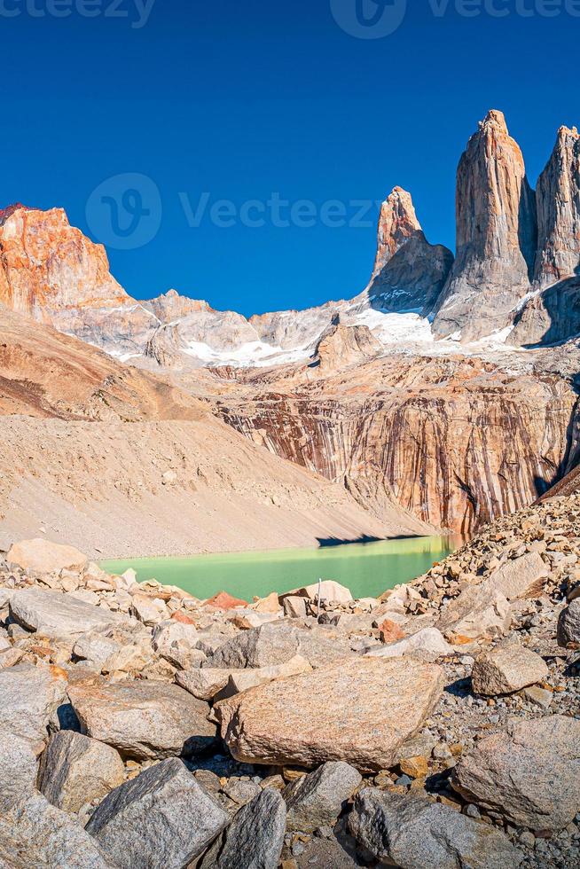 vista sul bellissimo parco nazionale torres del paine, le sue tre vette maggiori come denti giganteschi e laguna turchese, patagonia, cile, giornata di sole, cielo blu foto