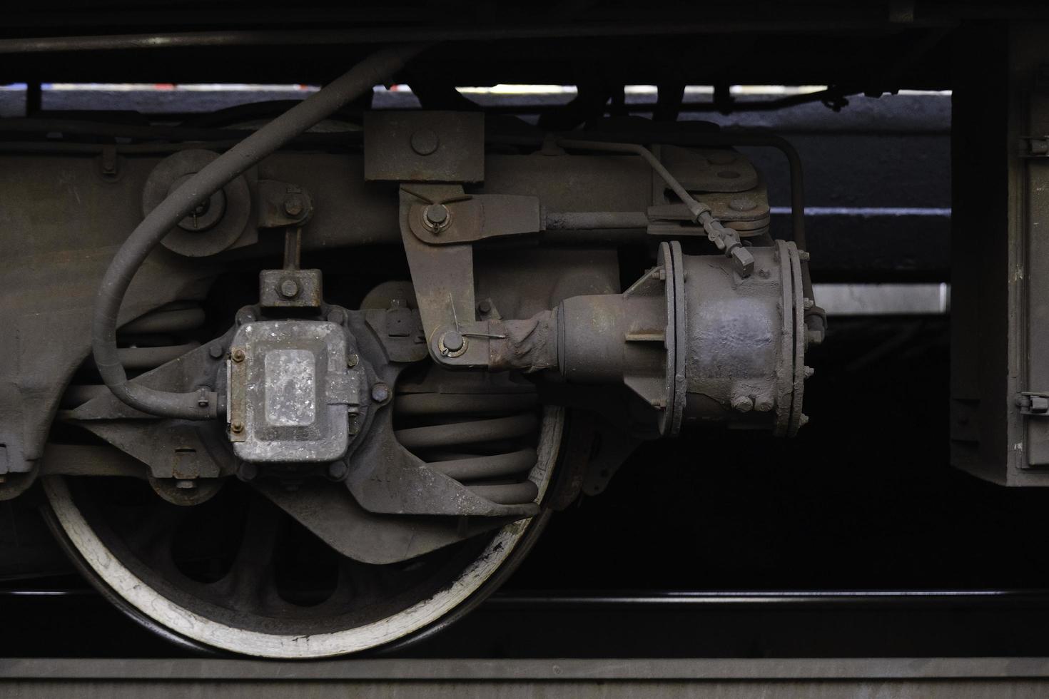 ruota in acciaio di un vagone ferroviario su una rotaia con dettagli, primo piano della ruota ferroviaria foto