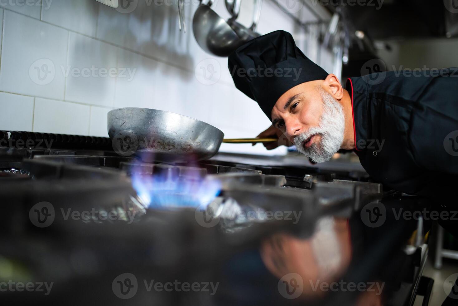un' capocuoco è cucinando su un' stufa foto