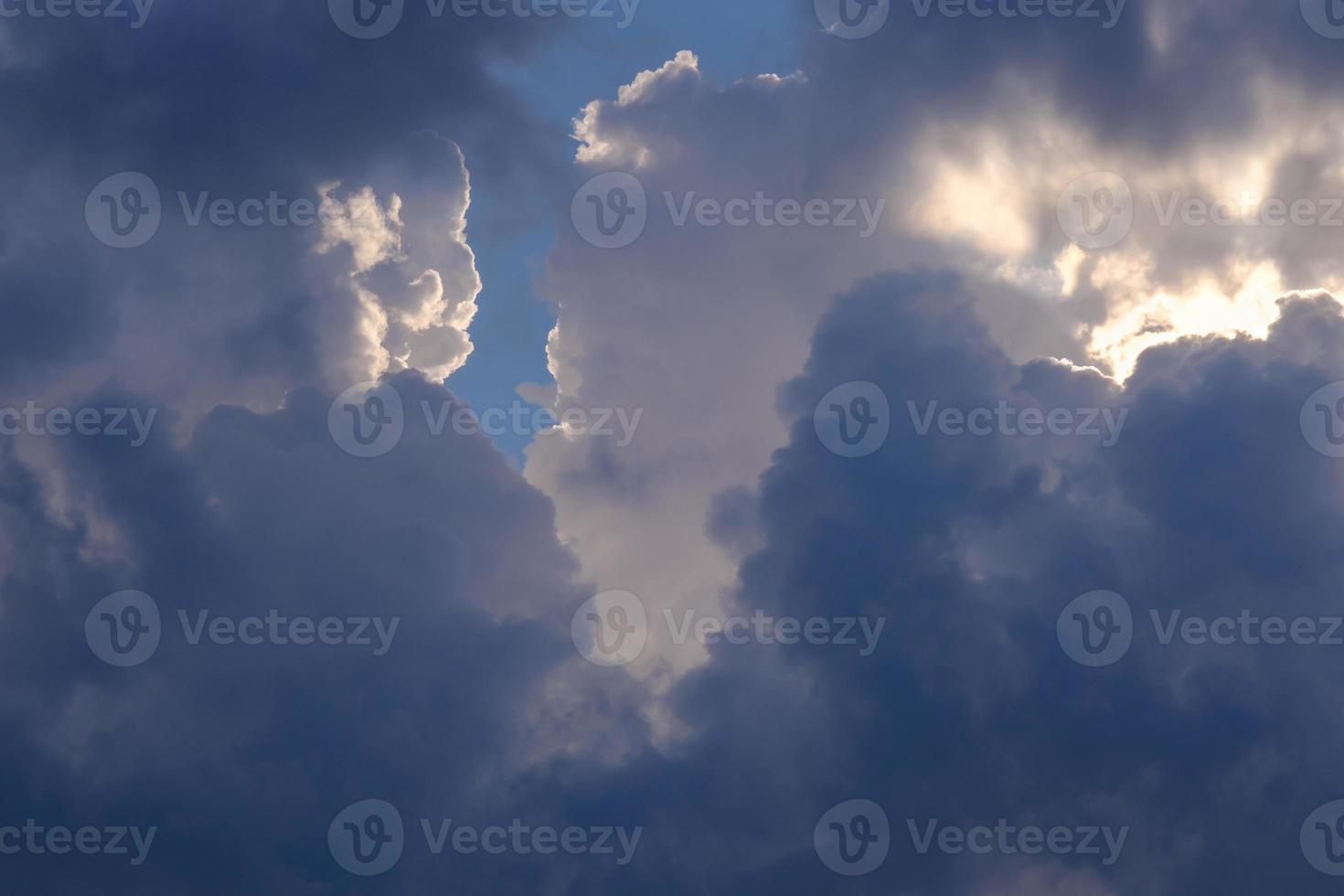 soffici nuvole bianche e scure nel cielo azzurro in una giornata nuvolosa foto