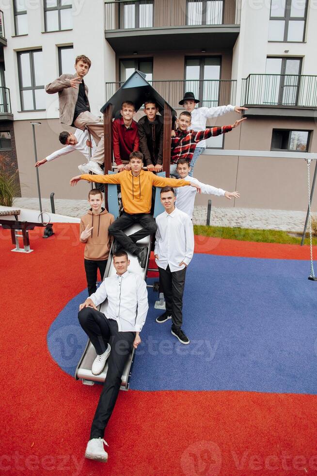 gruppo di molti contento adolescenti vestito nel casuale Abiti avendo divertimento e avendo divertimento vicino Università. concetto di amicizia, momenti di felicità. scuola amicizia foto