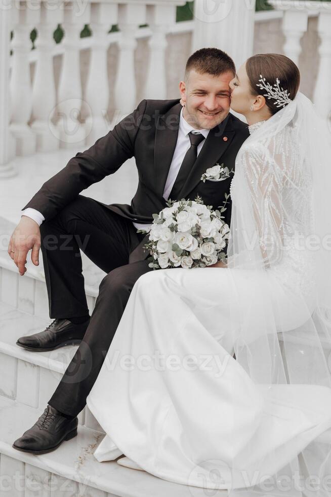 il sposa e sposo abbraccio vicino il in stile romano colonne. un squisito nozze foto