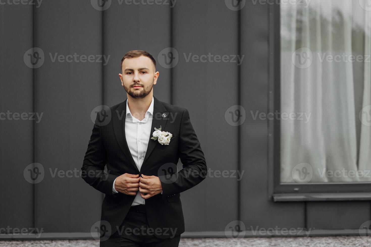 elegante e elegante sposo nel un' nero completo da uomo e bianca camicia su un' buio sfondo foto