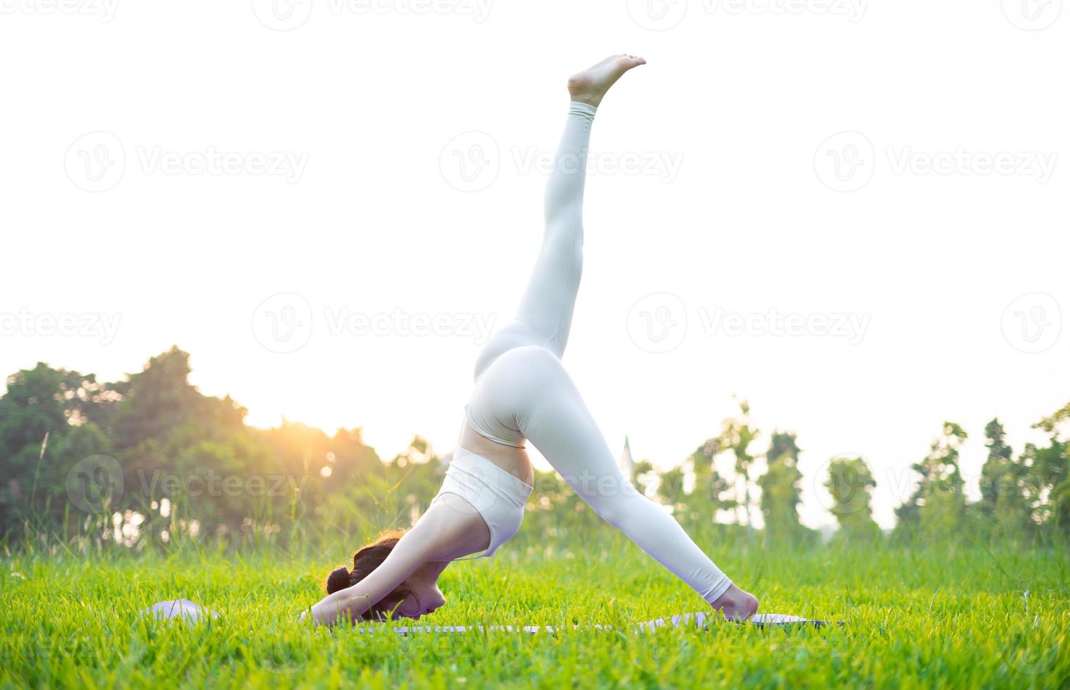 immagine di una donna asiatica che fa yoga all'aperto foto