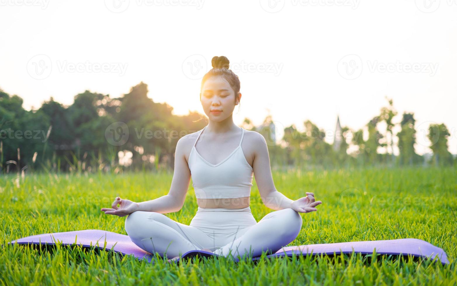 immagine di una donna asiatica che fa yoga all'aperto foto