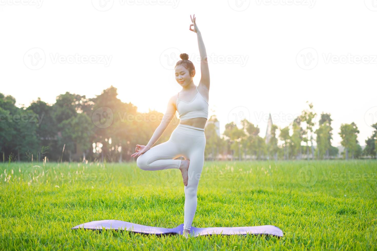 immagine di una donna asiatica che fa yoga all'aperto foto