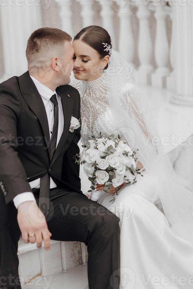 il sposa e sposo abbraccio vicino il in stile romano colonne. un squisito nozze foto