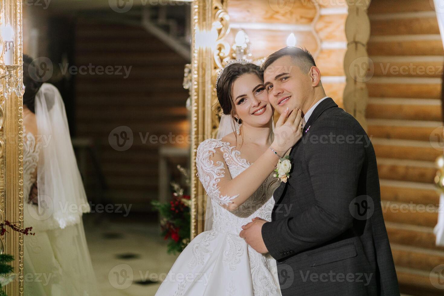 ritratto di un' contento sposa e sposo nel il sala di un' moderno Hotel vicino un' specchio. inverno nozze. foto