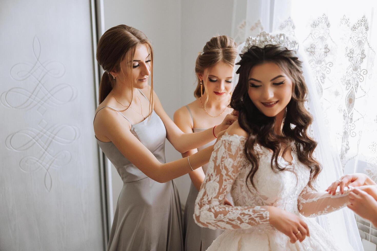 amici rallegrarsi con il sposa nel il mattina. essi prendere immagini, Sorridi, Aiuto il sposa allacciare sua vestire. foto