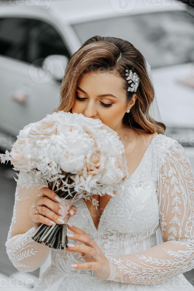 ritratto di un' bellissimo sposa con un' nozze mazzo di fiori, attraente donna nel un' nozze vestito con un' lungo velo. contento sposa donna. sposa con nozze trucco e pettinatura. inverno nozze foto