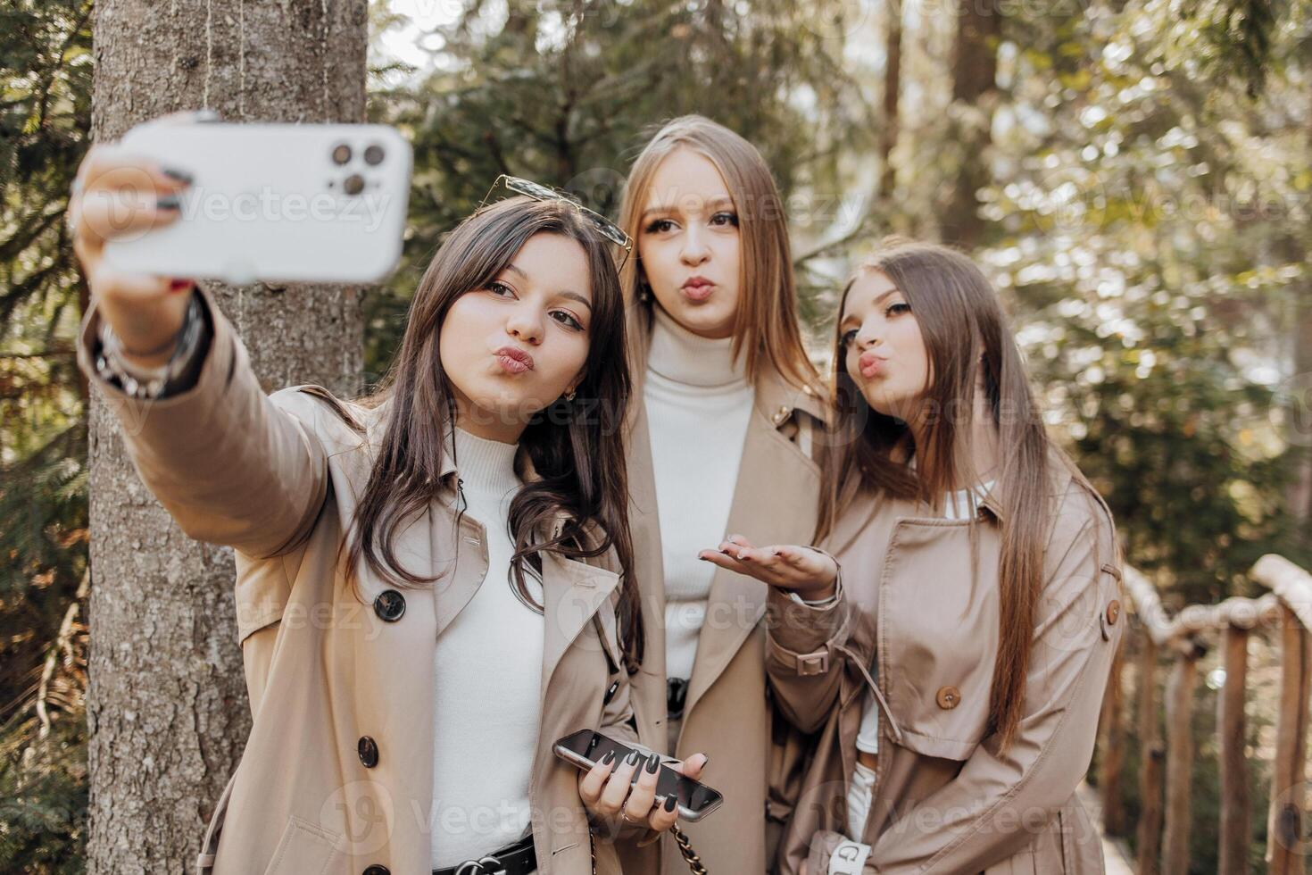 tre giovane donne assunzione autoscatto con inteligente mobile Telefono all'aperto - contento bellissimo femmina amici sorridente a telecamera all'aperto - stile di vita concetto con allegro ragazze godendo all'aperto vacanza. foto