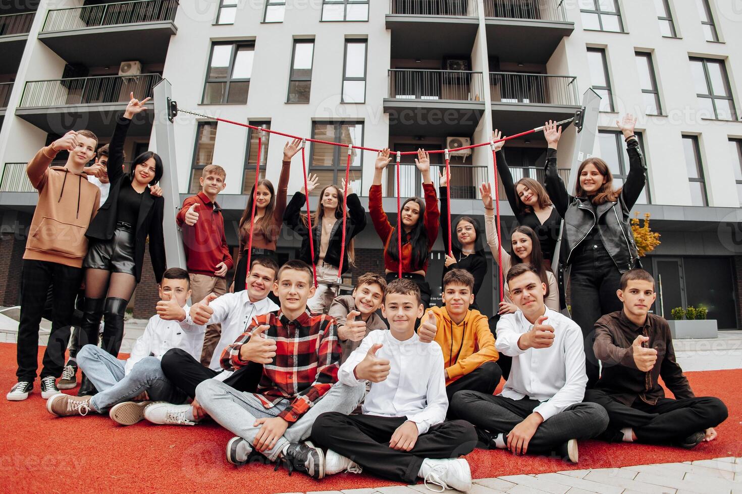 gruppo di molti contento adolescenti vestito nel casuale Abiti avendo divertimento e avendo divertimento vicino Università. concetto di amicizia, momenti di felicità. scuola amicizia foto