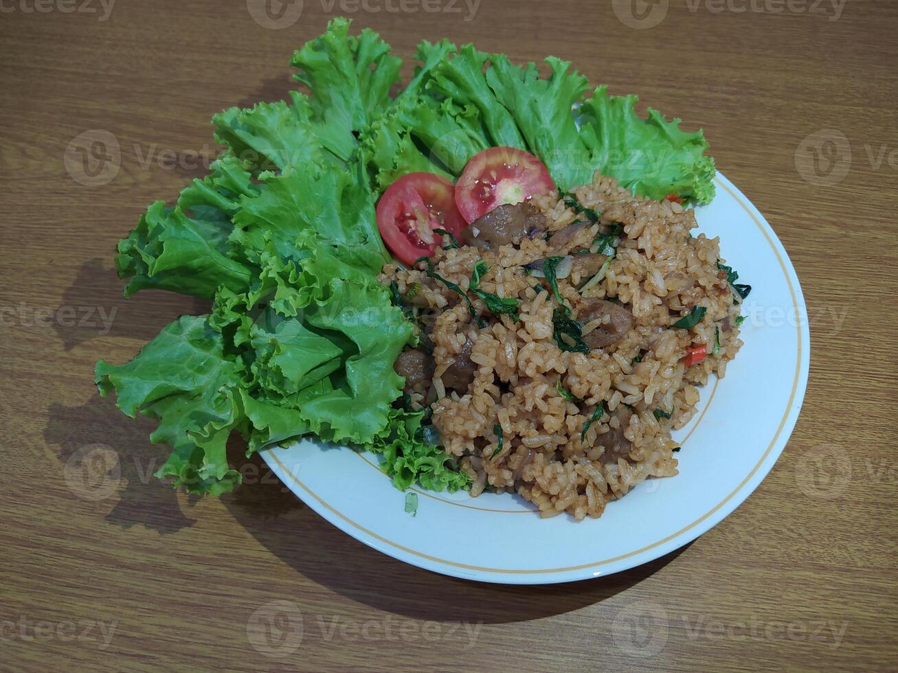 delizioso indonesiano fritte riso nasi goreng con molte di lattuga, mostarda verdura e pomodori servito su un' bianca piatto foto