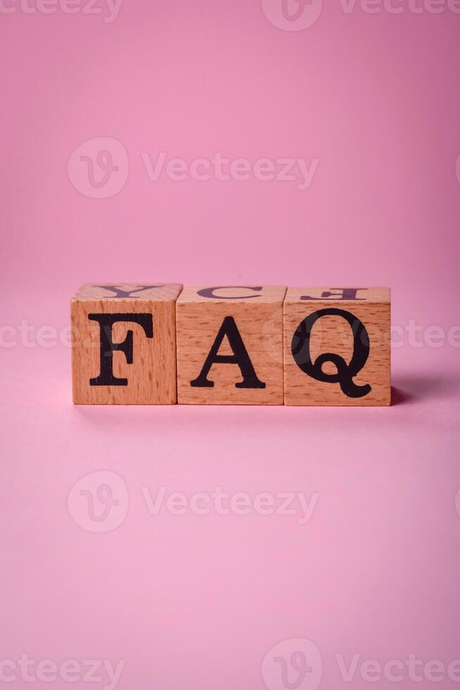 il iscrizione FAQ fatto su di di legno cubi su un' pianura sfondo foto