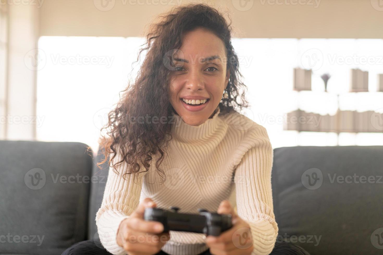 donna latina che gioca ai videogiochi con le mani che tengono il joystick foto