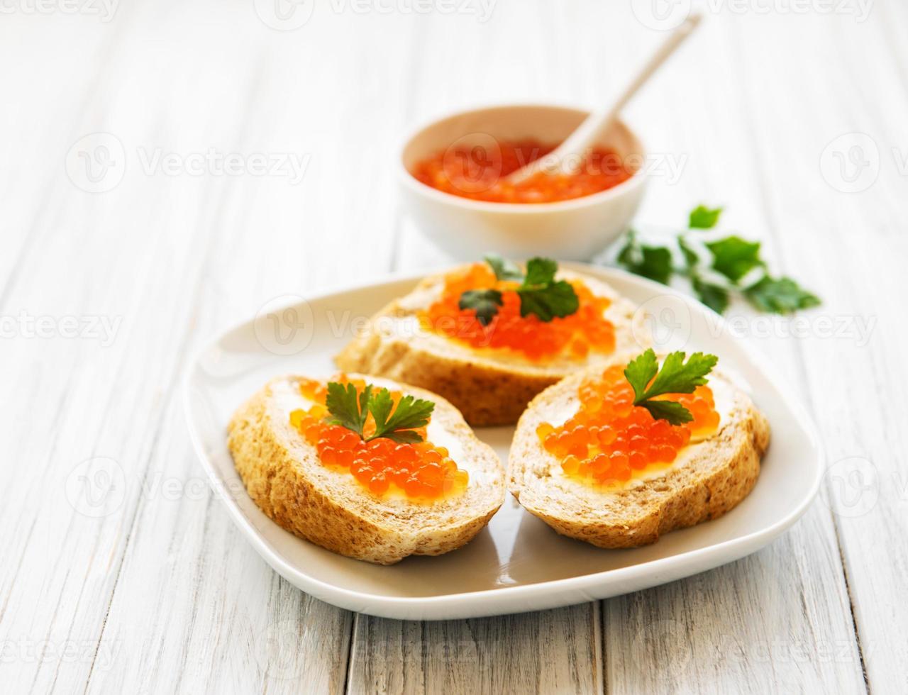 caviale rosso in ciotola e panini foto