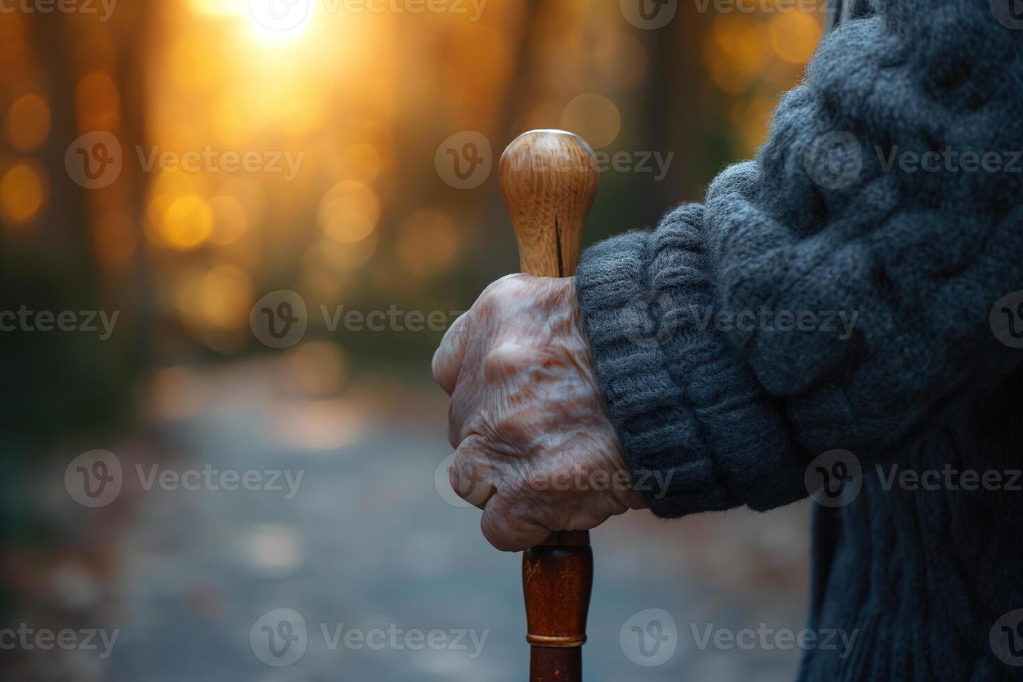 ai generato avvicinamento di un anziano di persona mano stringendo un' di legno canna per supporto durante un' camminare a tramonto. foto